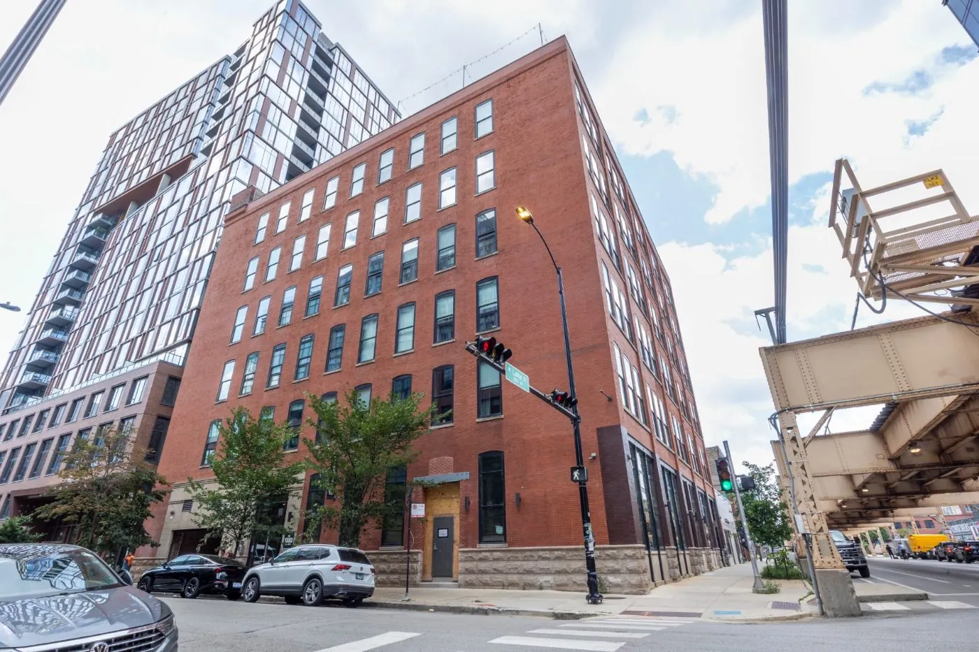 Red-brick exterior of 1101 W Lake Street at the corner of Lake Street beneath the L tracks in Fulton Market