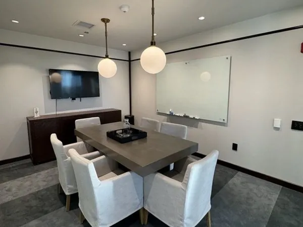 Galena meeting room—leather cantilever chairs, sheer curtains, and a wall-mounted display