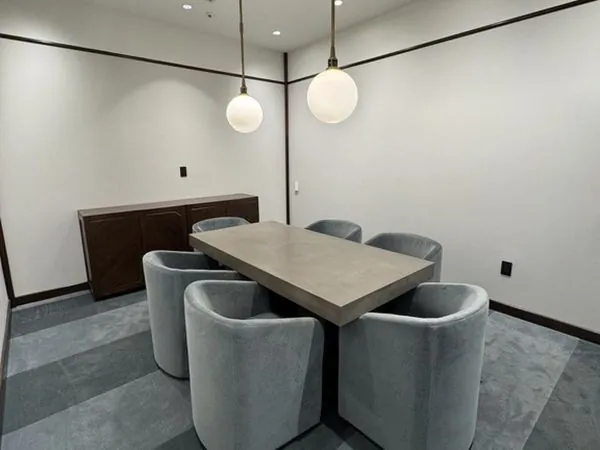 Roseland meeting room—concrete-top table with six grey velvet barrel chairs
