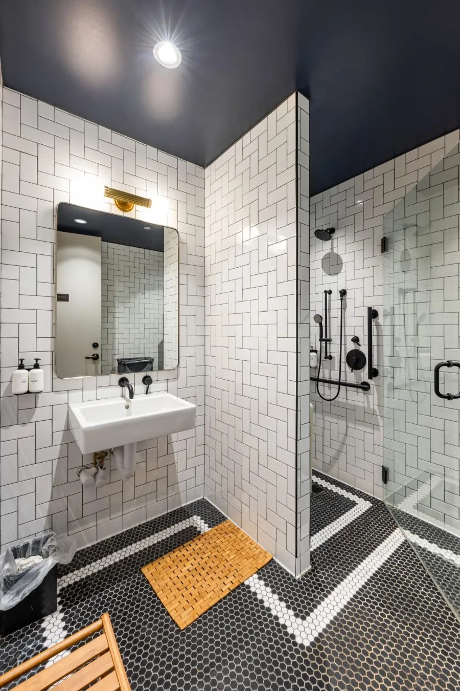 Onsite shower room with white tile, navy ceiling, and brass fixtures
